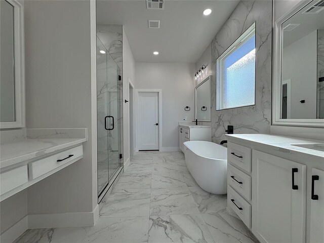 bathroom with vanity and shower with separate bathtub