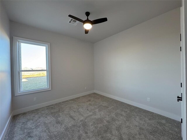 spare room with ceiling fan and light carpet