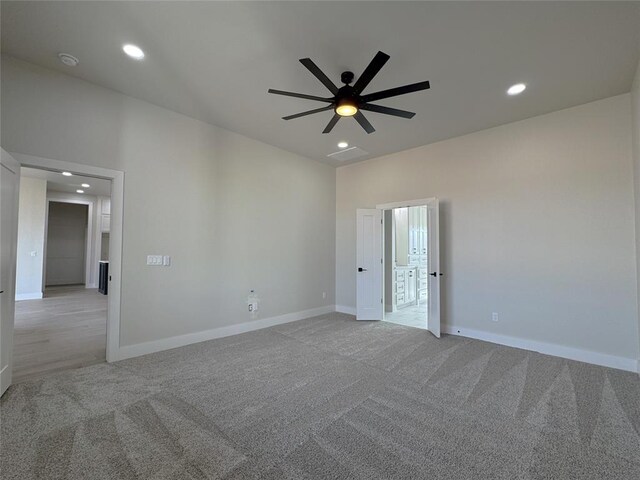 spare room with ceiling fan and light colored carpet