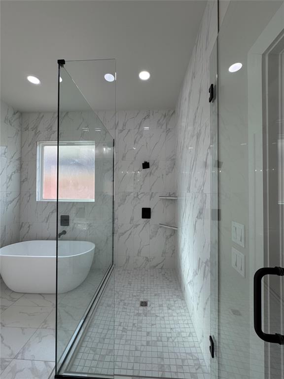 bathroom featuring shower with separate bathtub