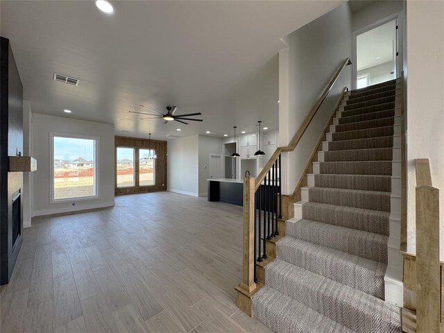 staircase featuring hardwood / wood-style flooring and ceiling fan