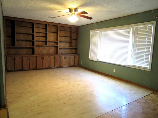 unfurnished living room featuring a textured ceiling, light hardwood / wood-style floors, and ceiling fan