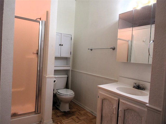 bathroom with walk in shower, toilet, vanity, and parquet flooring