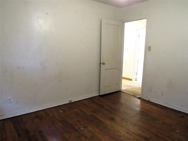 unfurnished room with dark wood-type flooring