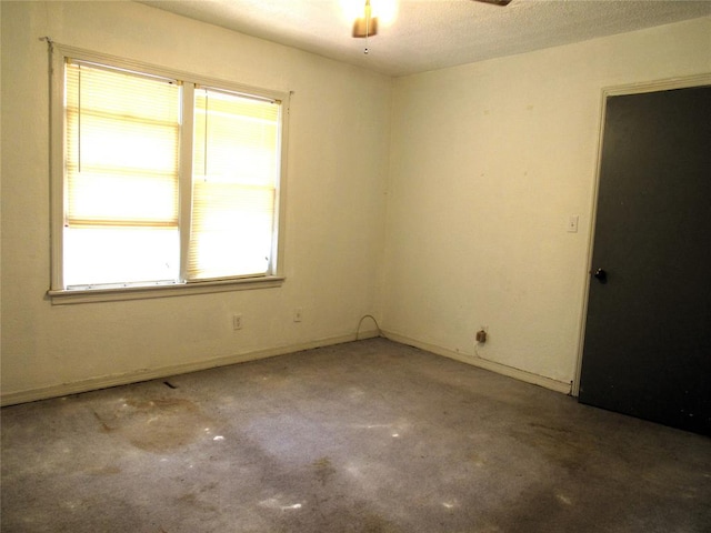 carpeted empty room featuring ceiling fan and a textured ceiling