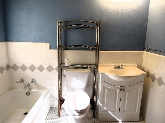 bathroom with a bathtub, vanity, tile walls, tile patterned flooring, and toilet