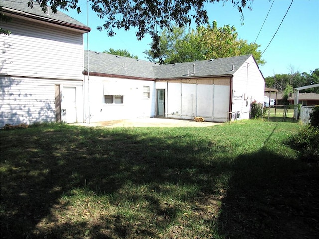 rear view of property featuring a yard and a patio area