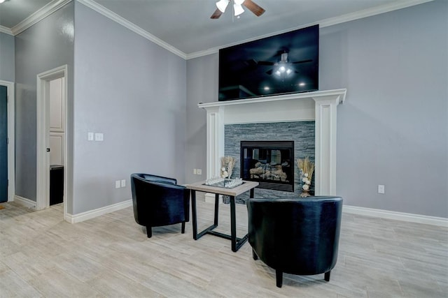 living room with crown molding, a stone fireplace, ceiling fan, and light hardwood / wood-style flooring