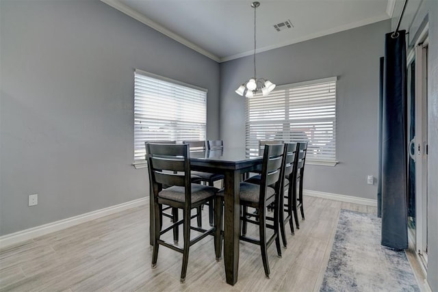 dining room with crown molding, a chandelier, and light hardwood / wood-style floors