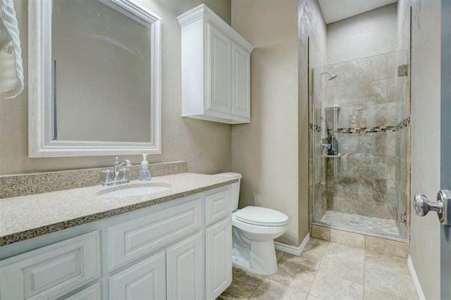 bathroom with vanity, toilet, and a shower with door