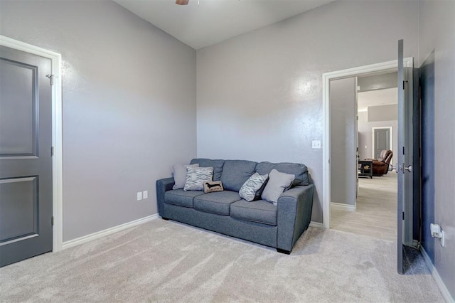 carpeted living room with ceiling fan