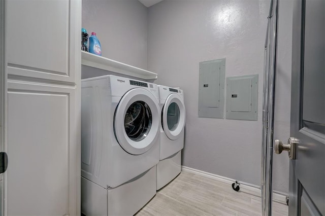 washroom with washing machine and dryer, electric panel, and light hardwood / wood-style flooring