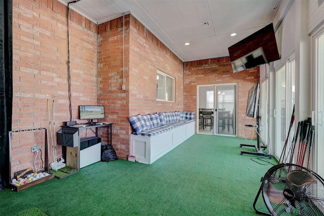 interior space with carpet flooring and brick wall