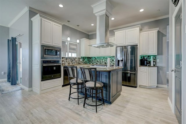 kitchen with pendant lighting, appliances with stainless steel finishes, a center island, white cabinets, and island exhaust hood