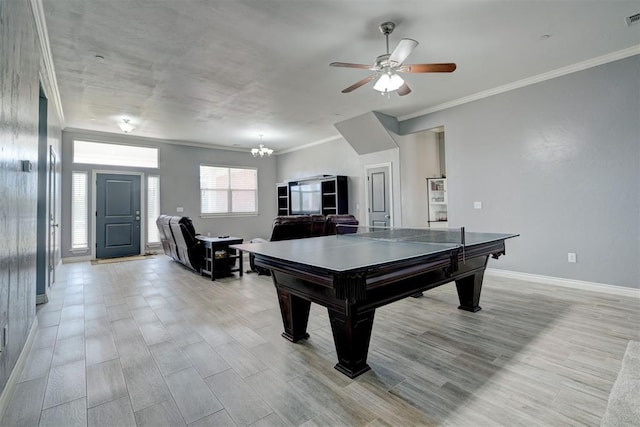 recreation room with ornamental molding, ceiling fan with notable chandelier, and light hardwood / wood-style flooring