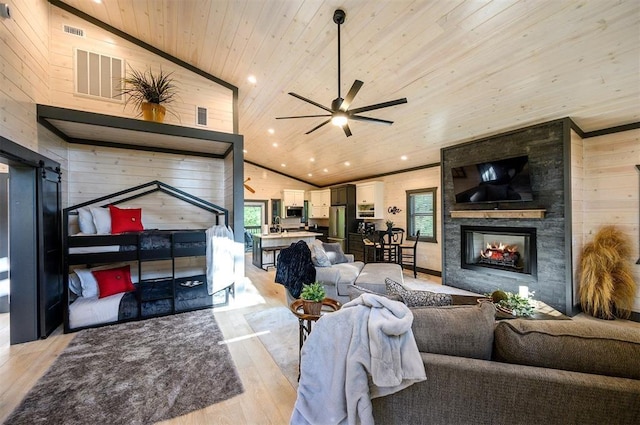 living room with wood ceiling, a large fireplace, ceiling fan, high vaulted ceiling, and light hardwood / wood-style floors