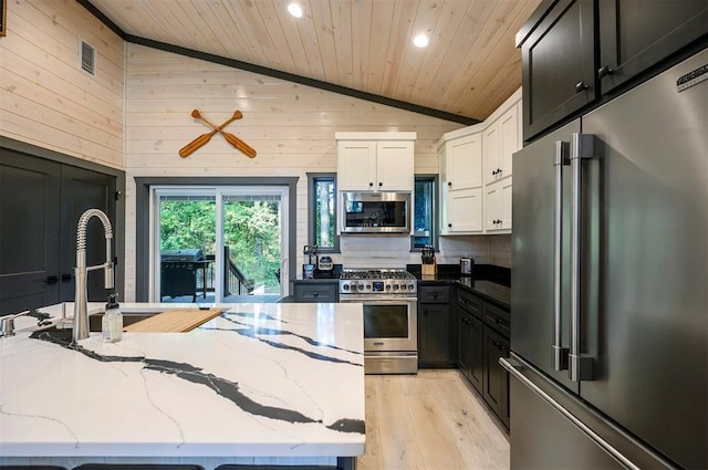 kitchen featuring white cabinets, light stone counters, high quality appliances, and wood ceiling