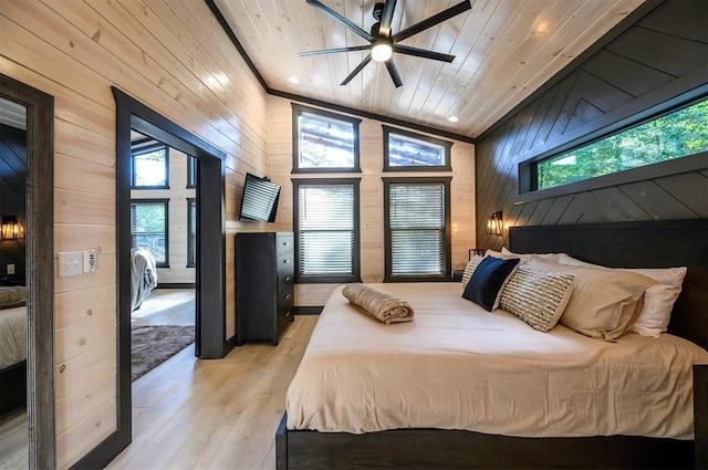 bedroom with multiple windows, wood walls, and light hardwood / wood-style floors