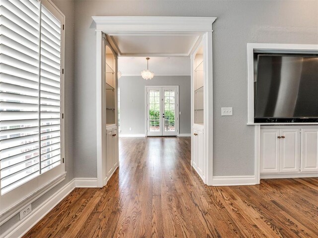 foyer entrance featuring wood-type flooring, crown molding, and french doors