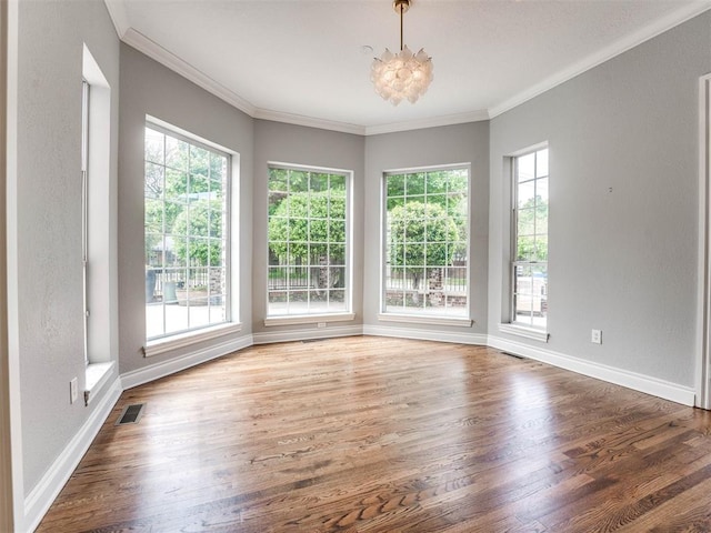 spare room featuring ornamental molding, dark hardwood / wood-style flooring, and a notable chandelier