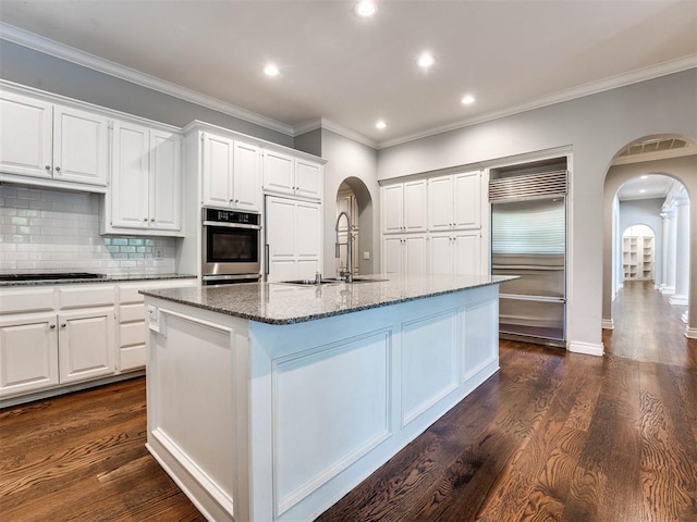 kitchen featuring a center island with sink, white cabinets, and stainless steel built in refrigerator