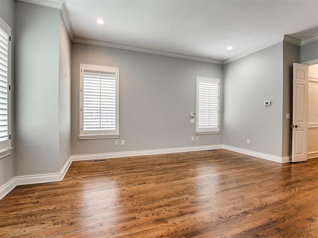 spare room featuring dark hardwood / wood-style flooring and crown molding