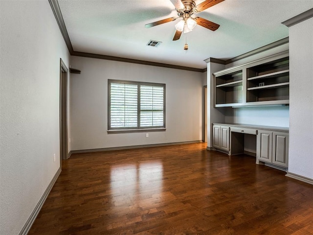 interior space with dark wood-type flooring, ceiling fan, built in desk, a textured ceiling, and ornamental molding