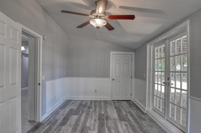 empty room featuring french doors, vaulted ceiling, ceiling fan, and hardwood / wood-style floors