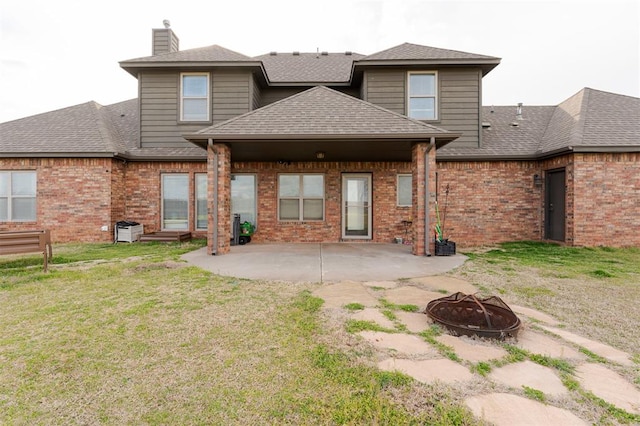 back of property featuring a yard, a patio, a fire pit, and central AC