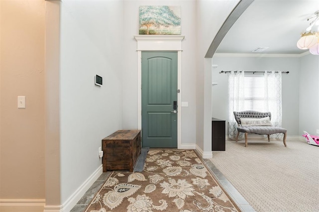 carpeted entrance foyer with crown molding