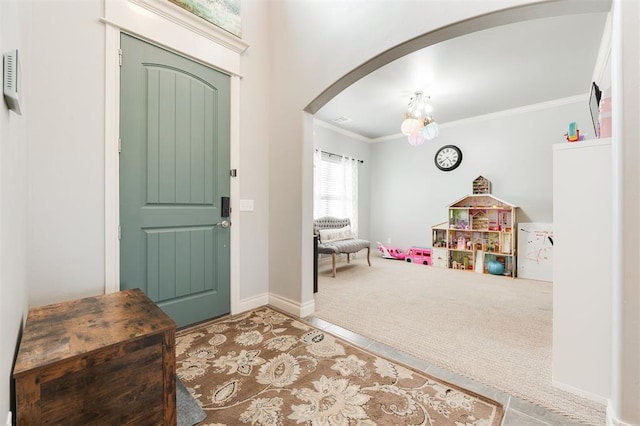 carpeted foyer featuring crown molding