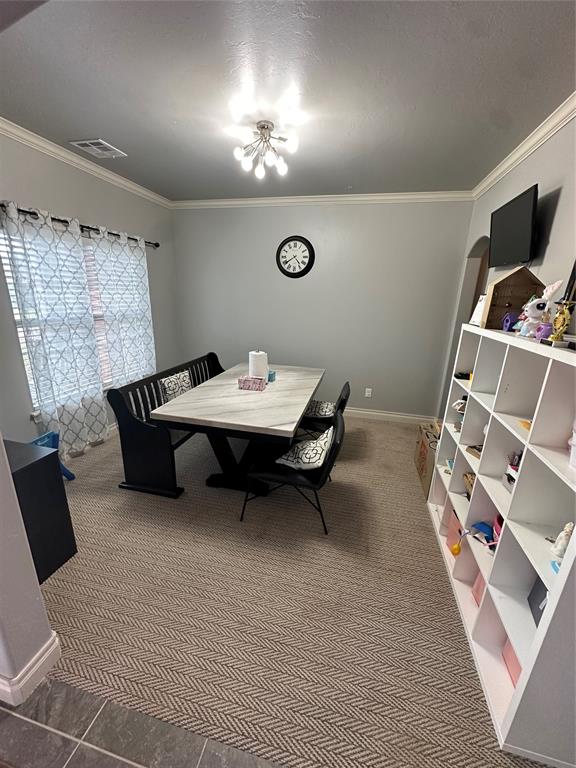 dining space with dark carpet and ornamental molding