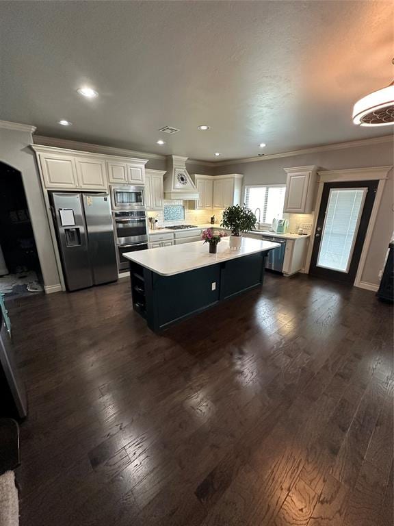 kitchen with white cabinets, a center island, dark hardwood / wood-style flooring, and appliances with stainless steel finishes