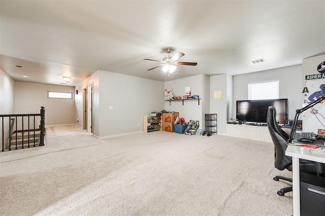 carpeted office space with ceiling fan