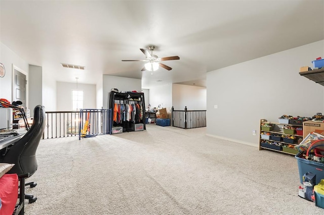 carpeted office space with ceiling fan