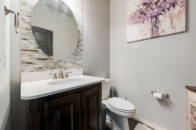 bathroom with vanity, toilet, and decorative backsplash