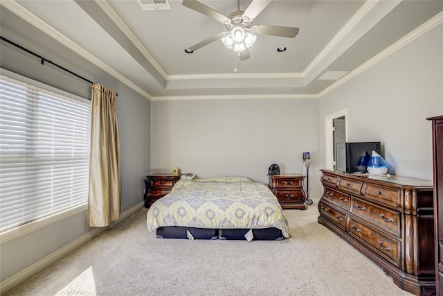 carpeted bedroom featuring baseboards, a tray ceiling, ceiling fan, and ornamental molding