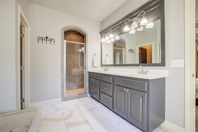 bathroom featuring baseboards, marble finish floor, a sink, and a shower stall