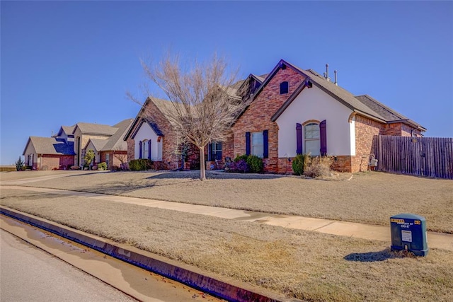 view of front facade featuring fence and brick siding