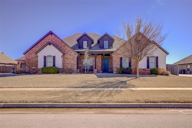 view of front of home featuring brick siding and fence