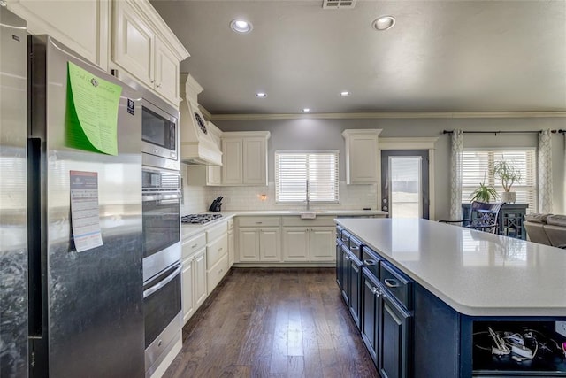 kitchen with tasteful backsplash, white cabinets, appliances with stainless steel finishes, light countertops, and blue cabinetry