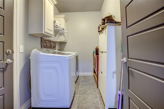 laundry room featuring light tile patterned flooring, independent washer and dryer, cabinet space, and baseboards