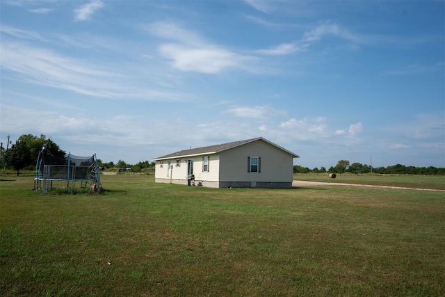 view of property exterior featuring a trampoline and a lawn