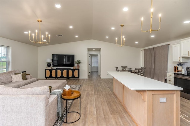 kitchen with a kitchen breakfast bar, light hardwood / wood-style flooring, a spacious island, lofted ceiling, and stainless steel electric stove