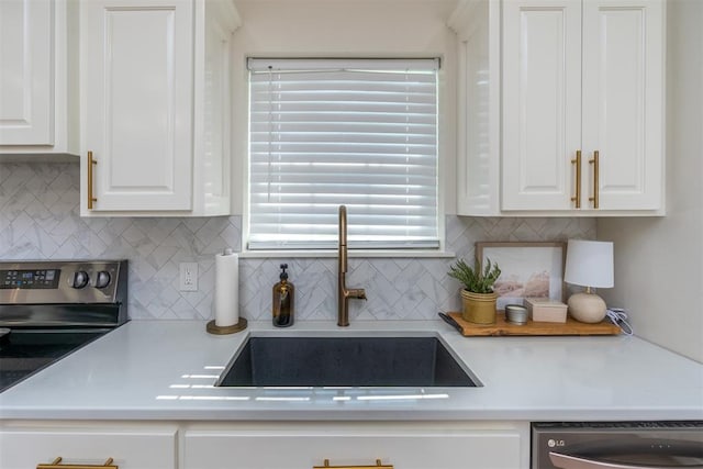 kitchen with white cabinets, backsplash, stainless steel appliances, and sink