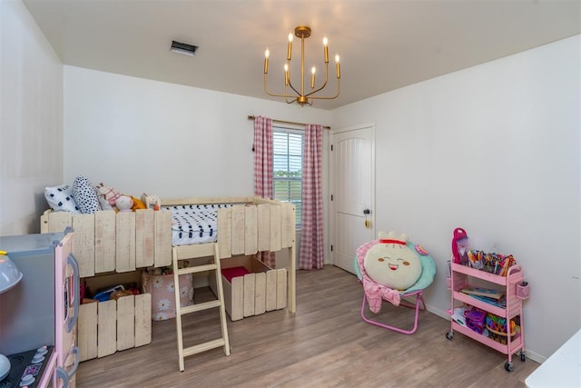 bedroom with a chandelier and hardwood / wood-style flooring