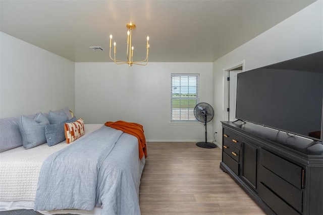 bedroom featuring a notable chandelier and light wood-type flooring