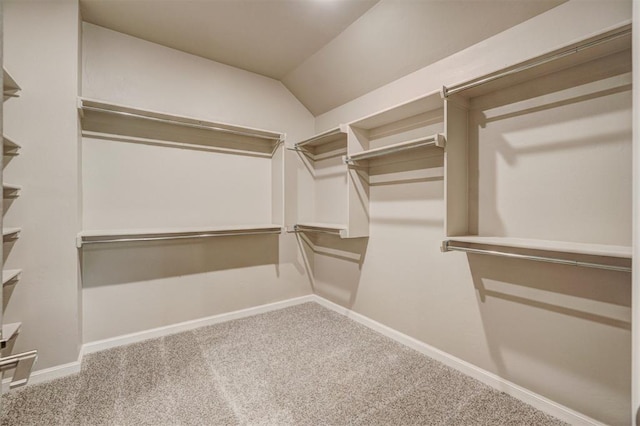 spacious closet with carpet flooring and vaulted ceiling