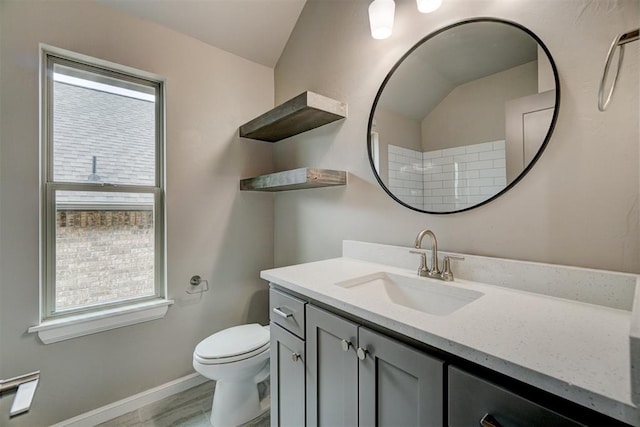 bathroom featuring plenty of natural light, vanity, and vaulted ceiling