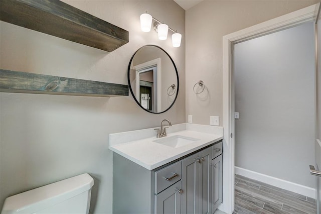 bathroom with vanity, toilet, and wood-type flooring